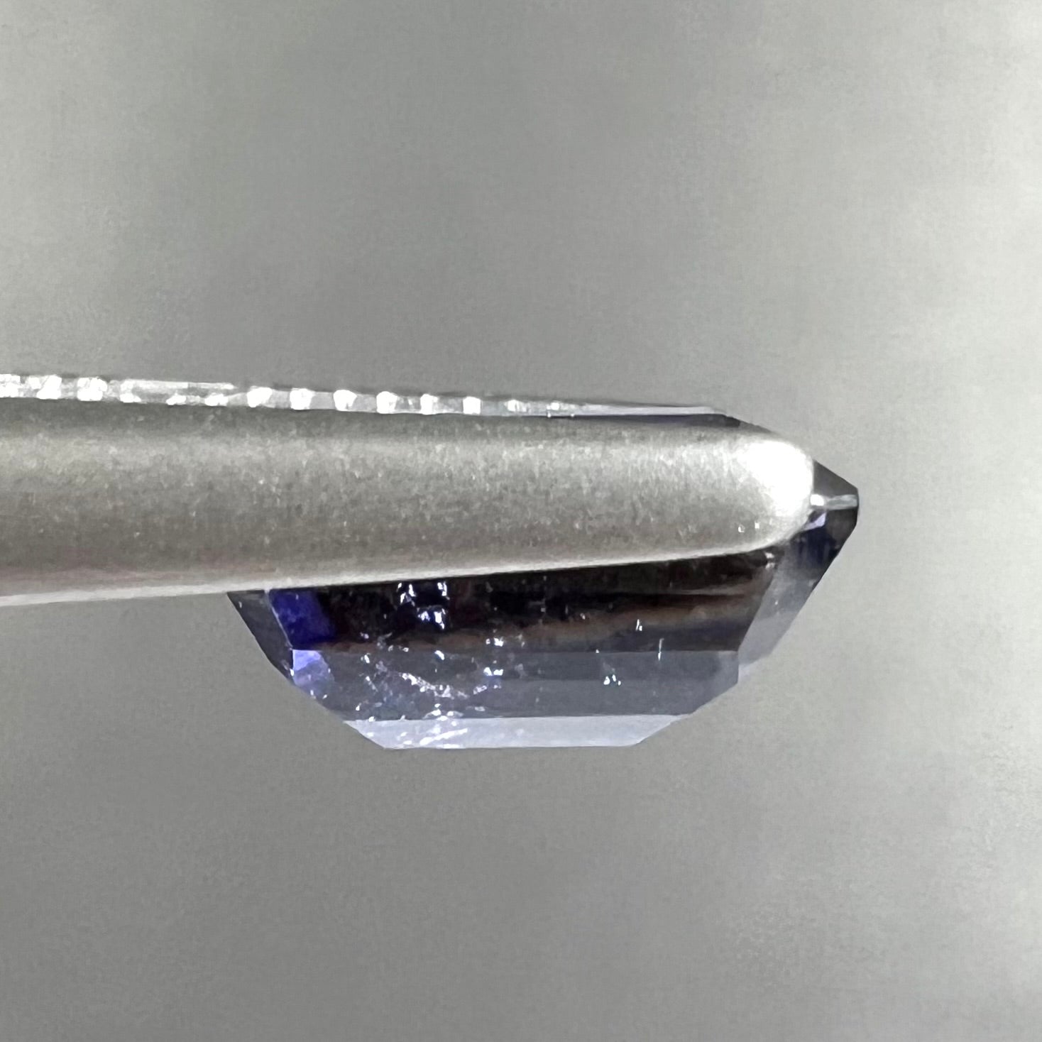 A loose, emerald cut blue iolite gemstone.