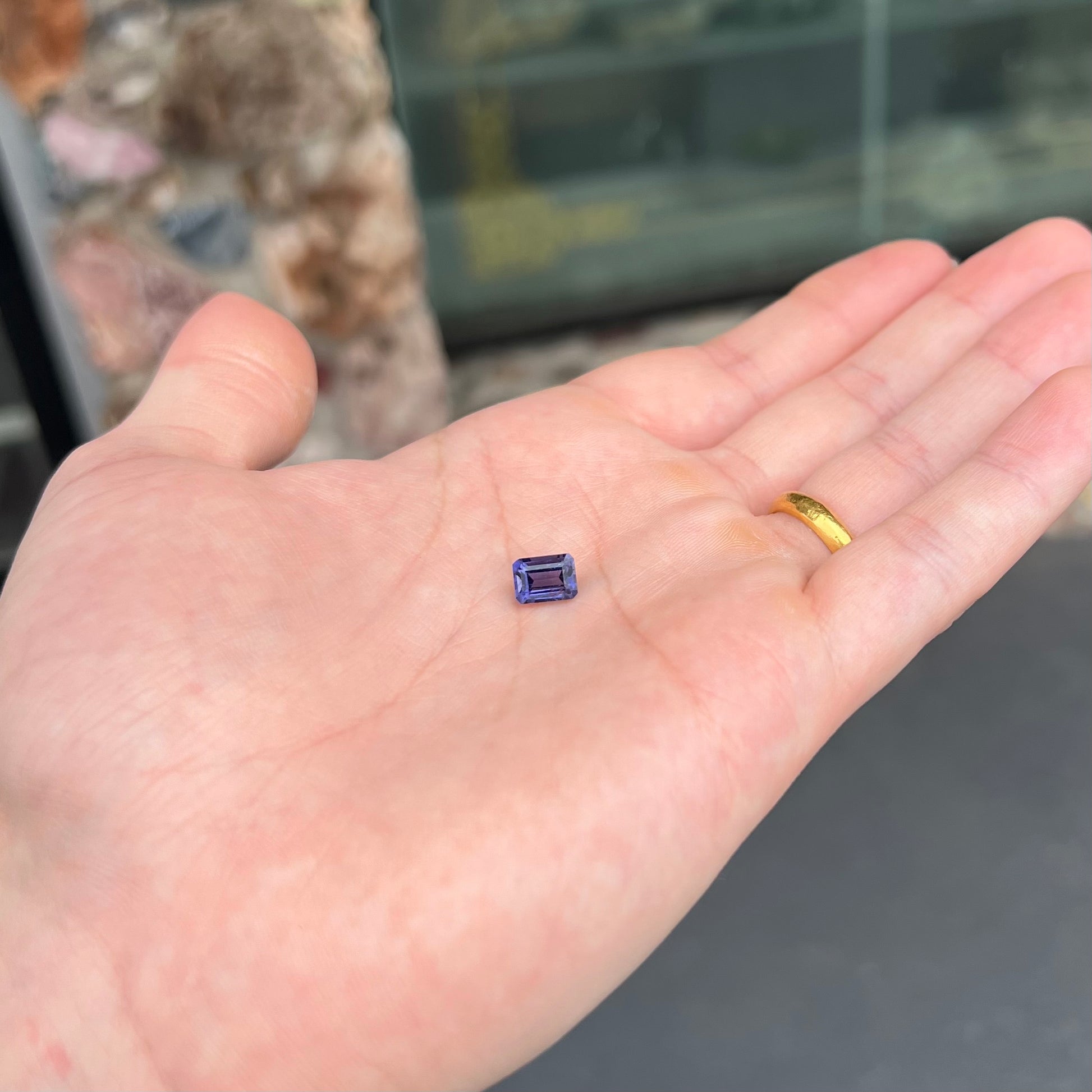 A loose, emerald cut blue iolite gemstone.