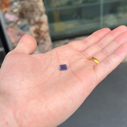 A loose, emerald cut blue iolite gemstone.