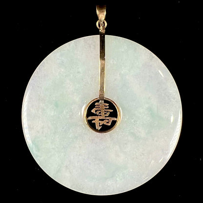 A light green jadeite jade bi pendant with a yellow gold bail and Chinese character symbol for "long life."