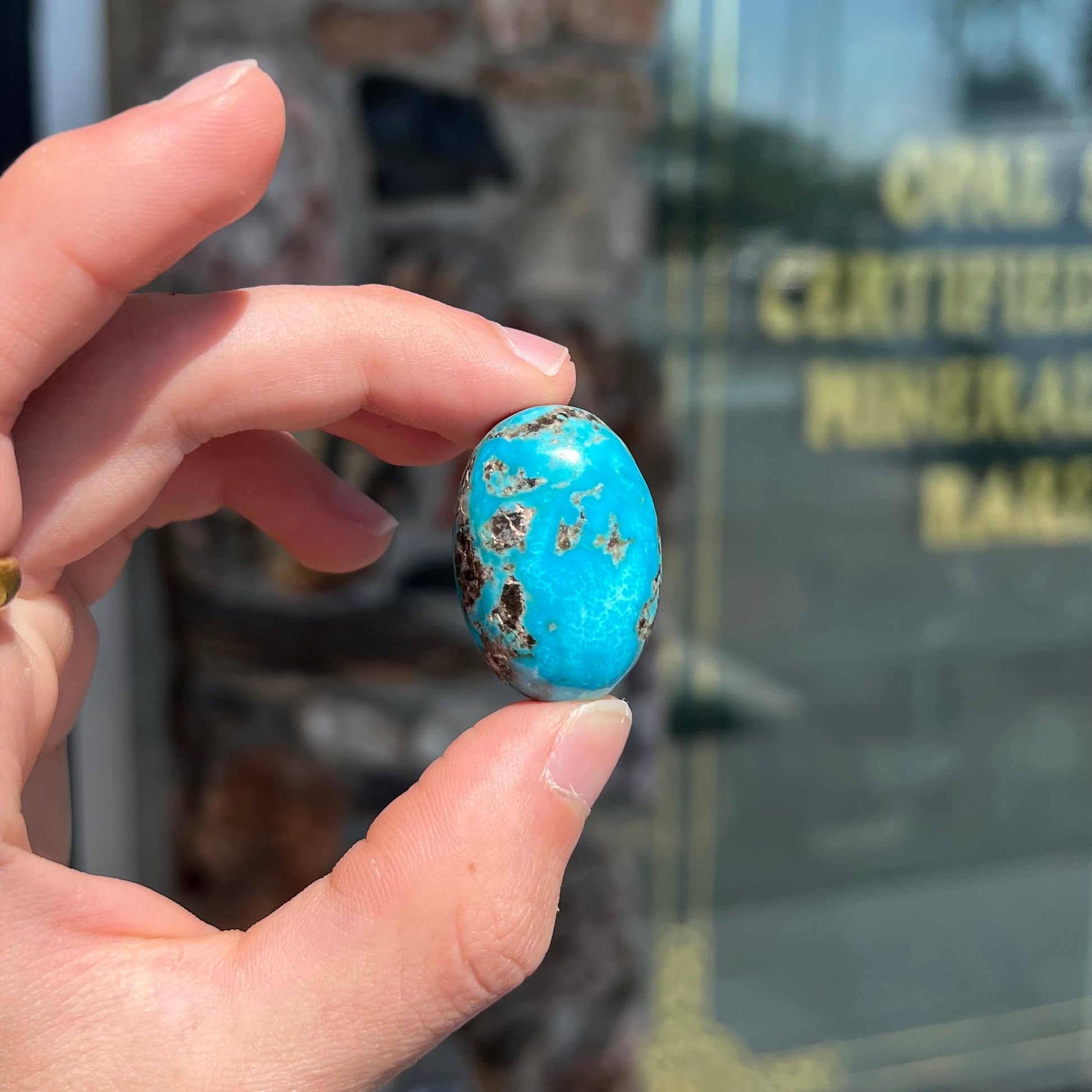 A loose, oval cabochon cut turquoise stone from Kingman, Arizona.