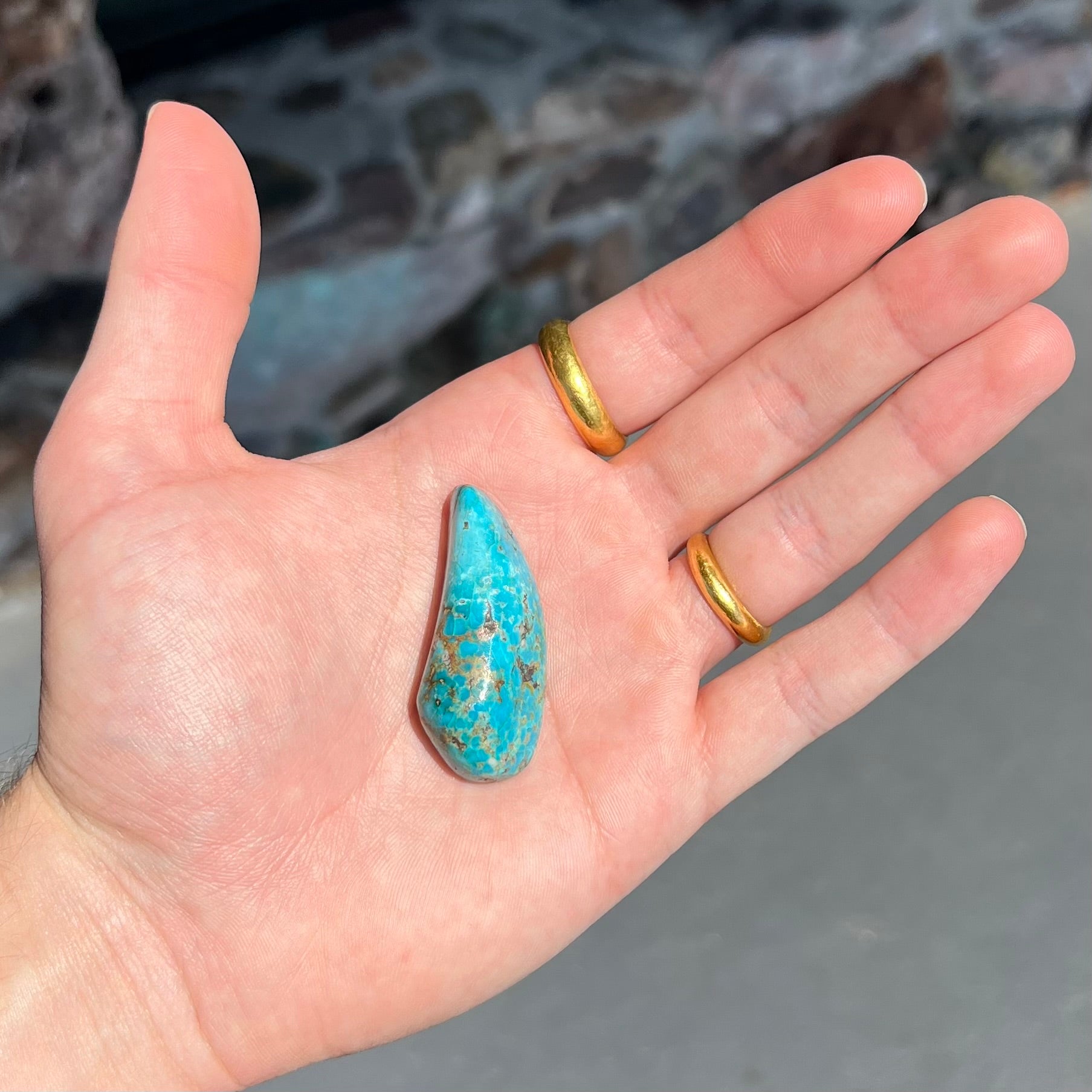 A loose, freeform cabochon cut Kingman turquoise stone from Arizona.  The stone is blue with gray and brown matrix.