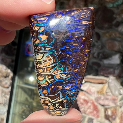A loose boulder opal stone from Koroit, Australia.  The opal has a blue and purple pattern.