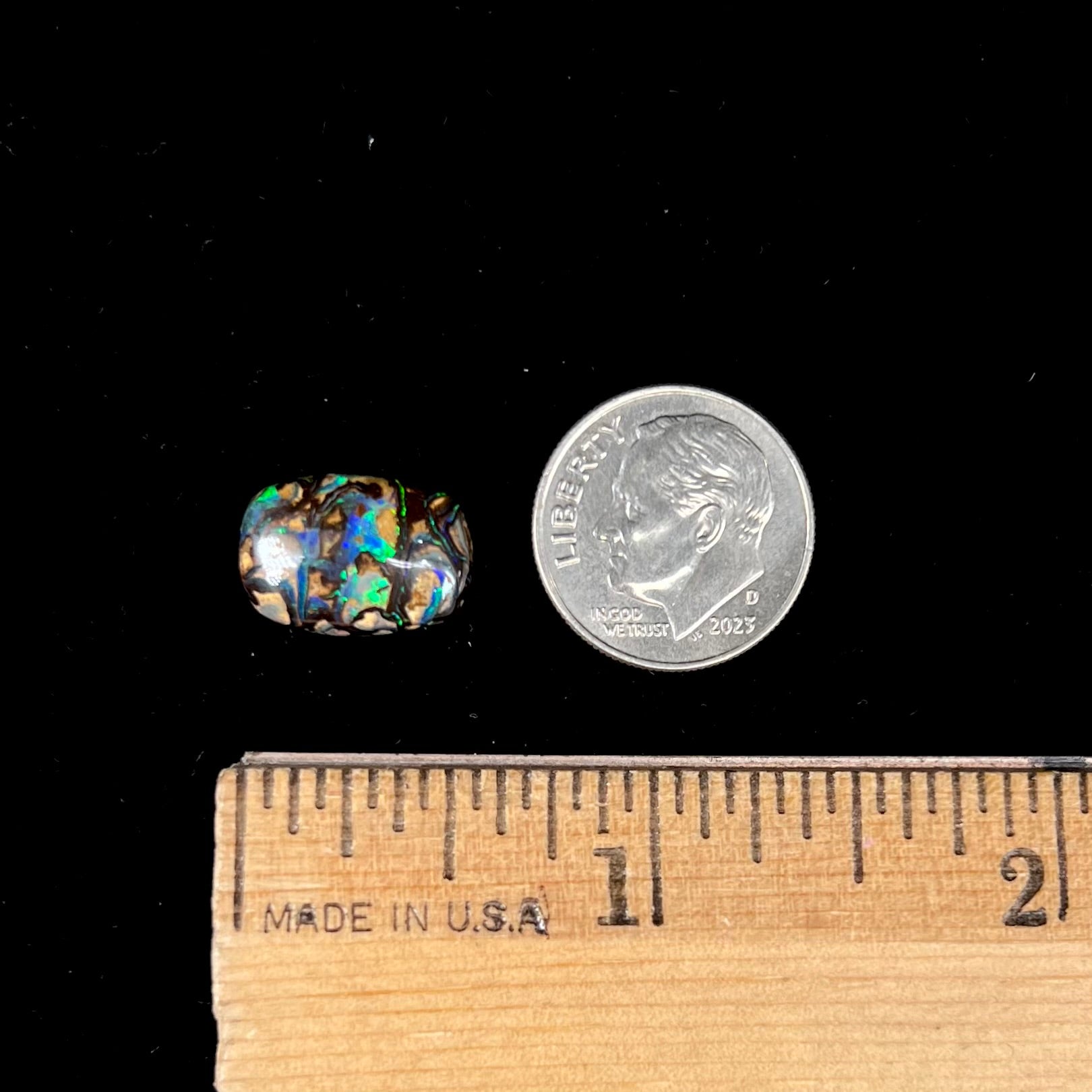 A loose, Koroit boulder opal stone.  The opal plays bright blue and green colors on a patterned matrix.