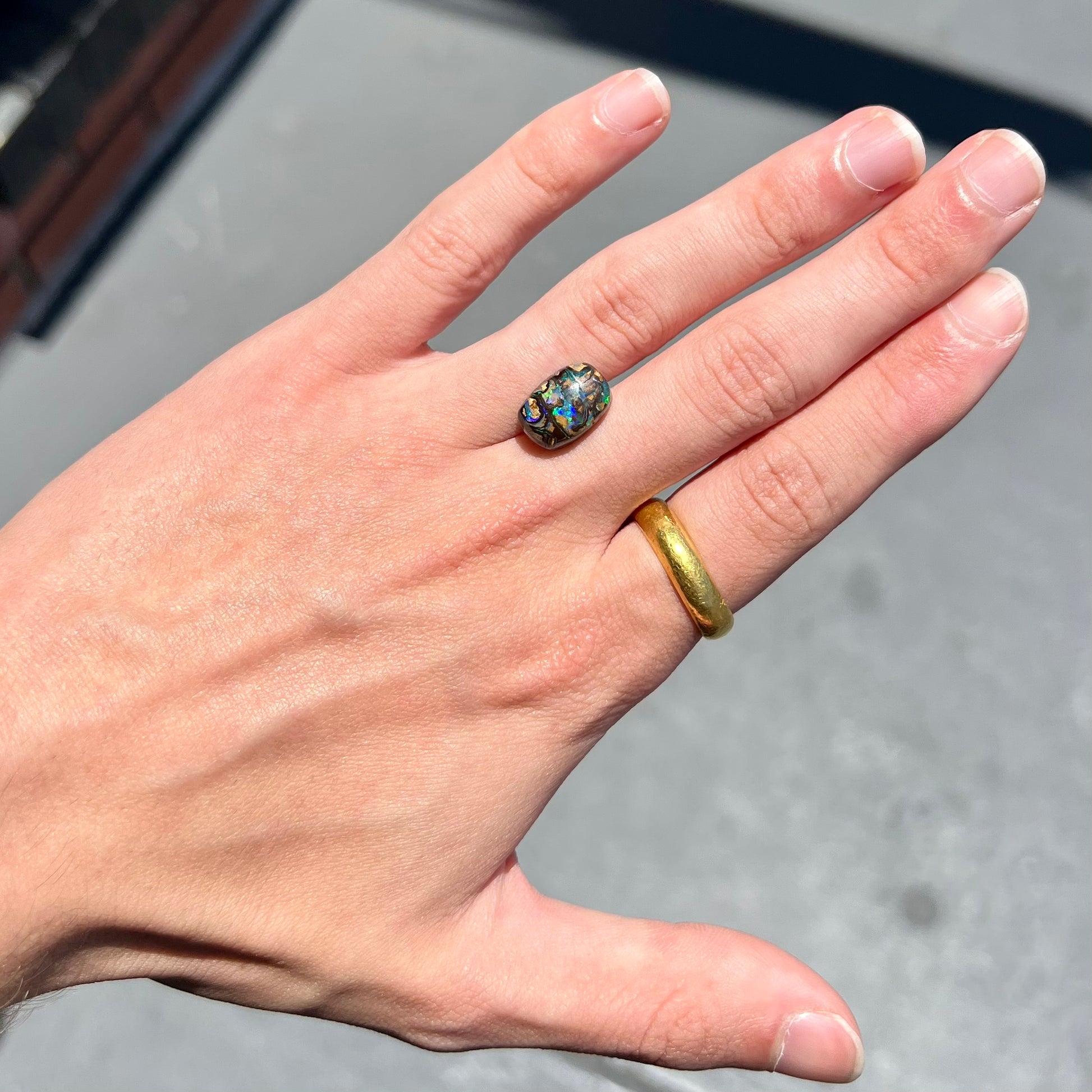 A loose, Koroit boulder opal stone.  The opal plays bright blue and green colors on a patterned matrix.
