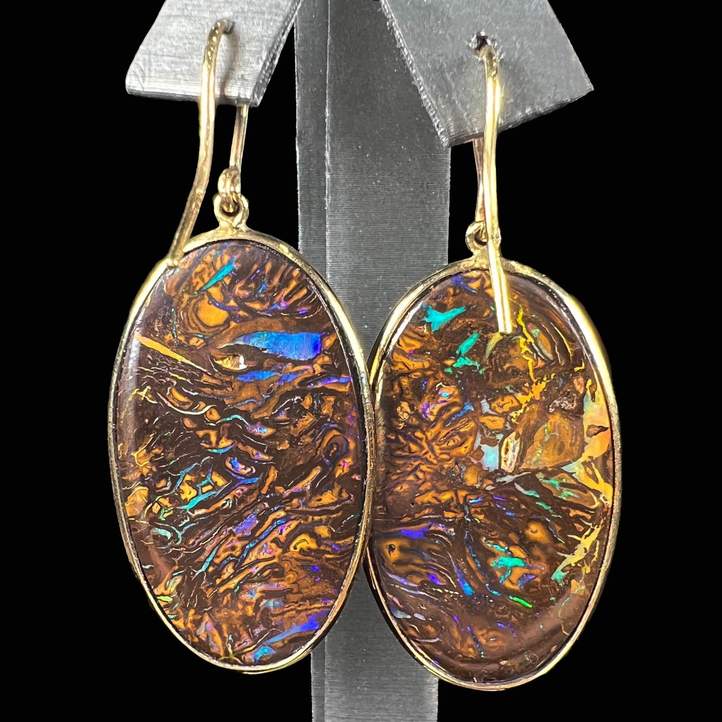 A pair of Koroit boulder opal dangle earrings set in yellow gold bezels.