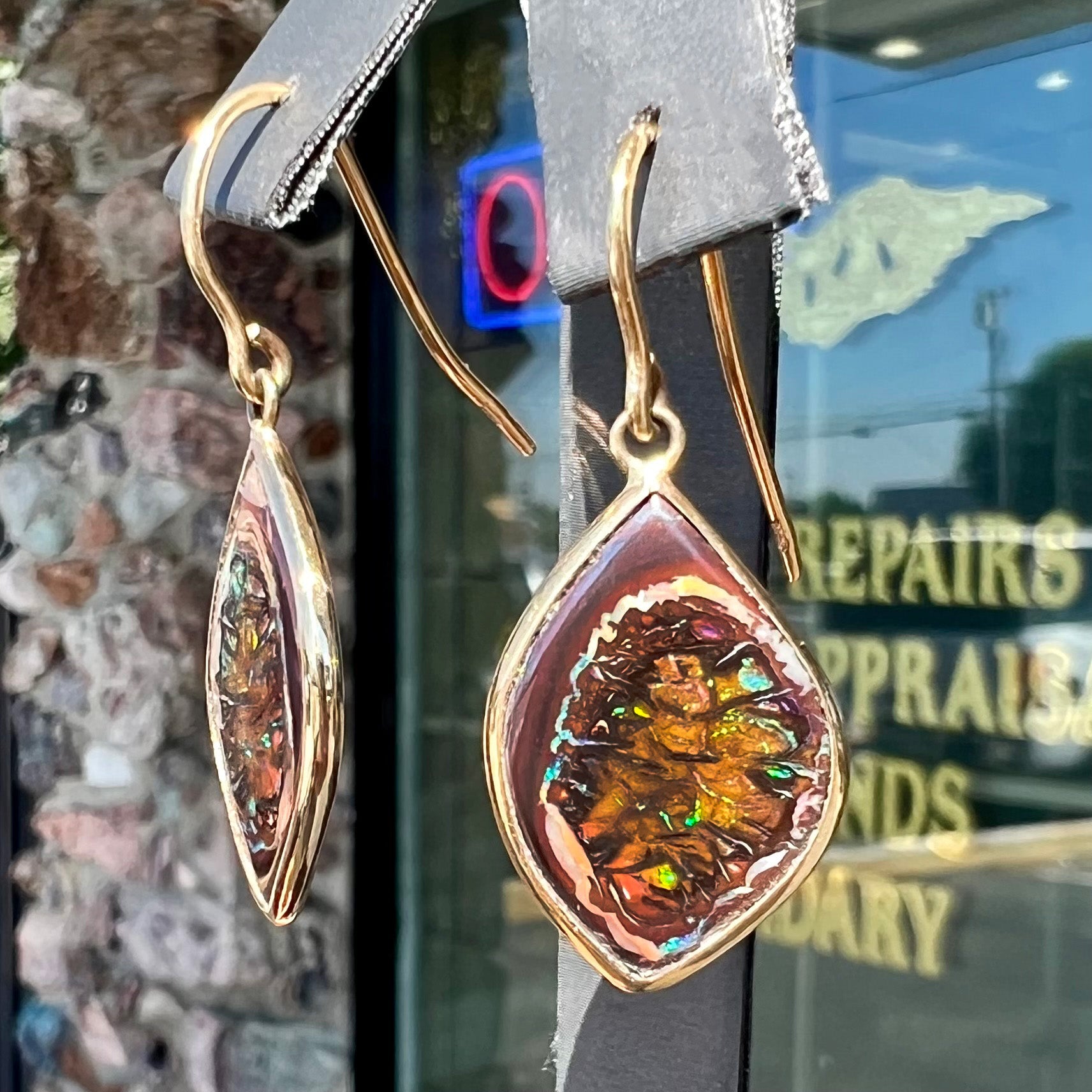 A pair of yellow gold dangle earrings bezel set with natural boulder opals from Koroit, Australia.