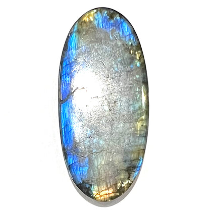 A loose, oval cabochon cut labradorite stone.  The stone is green with bright blue and yellow flashes.