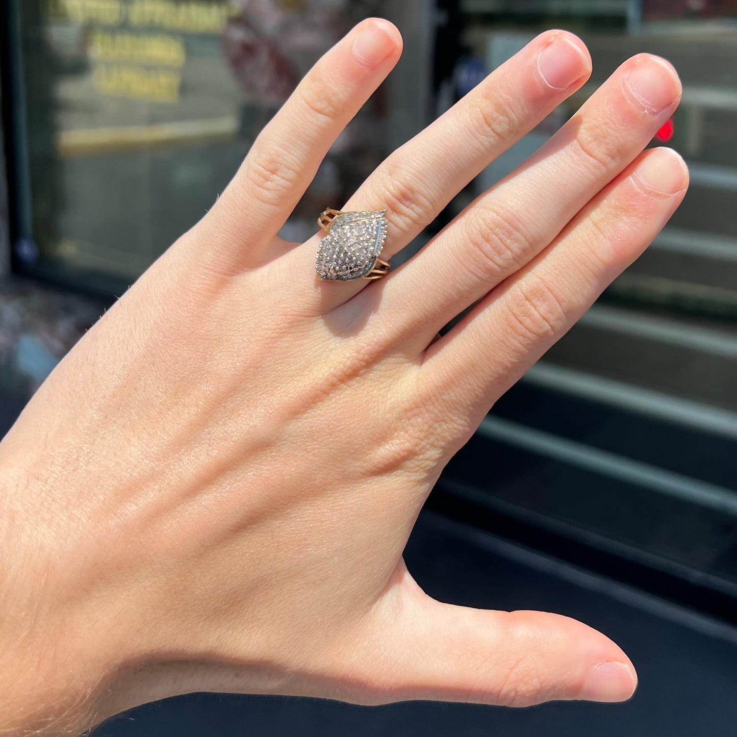 A ladies' yellow gold and diamond cluster ring.  The diamonds are round and baguette shaped, and the ring is navette shaped.