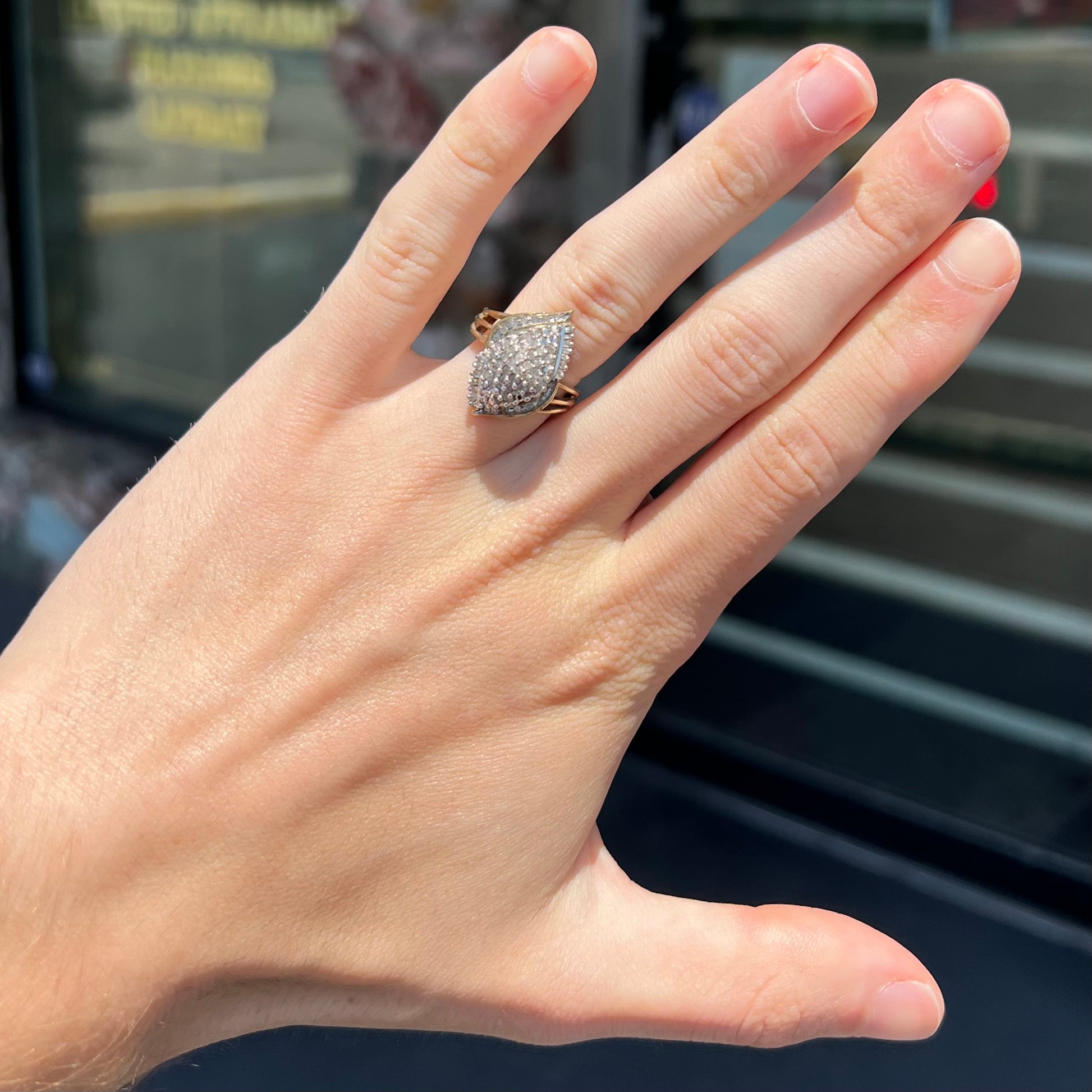 A ladies' yellow gold and diamond cluster ring.  The diamonds are round and baguette shaped, and the ring is navette shaped.