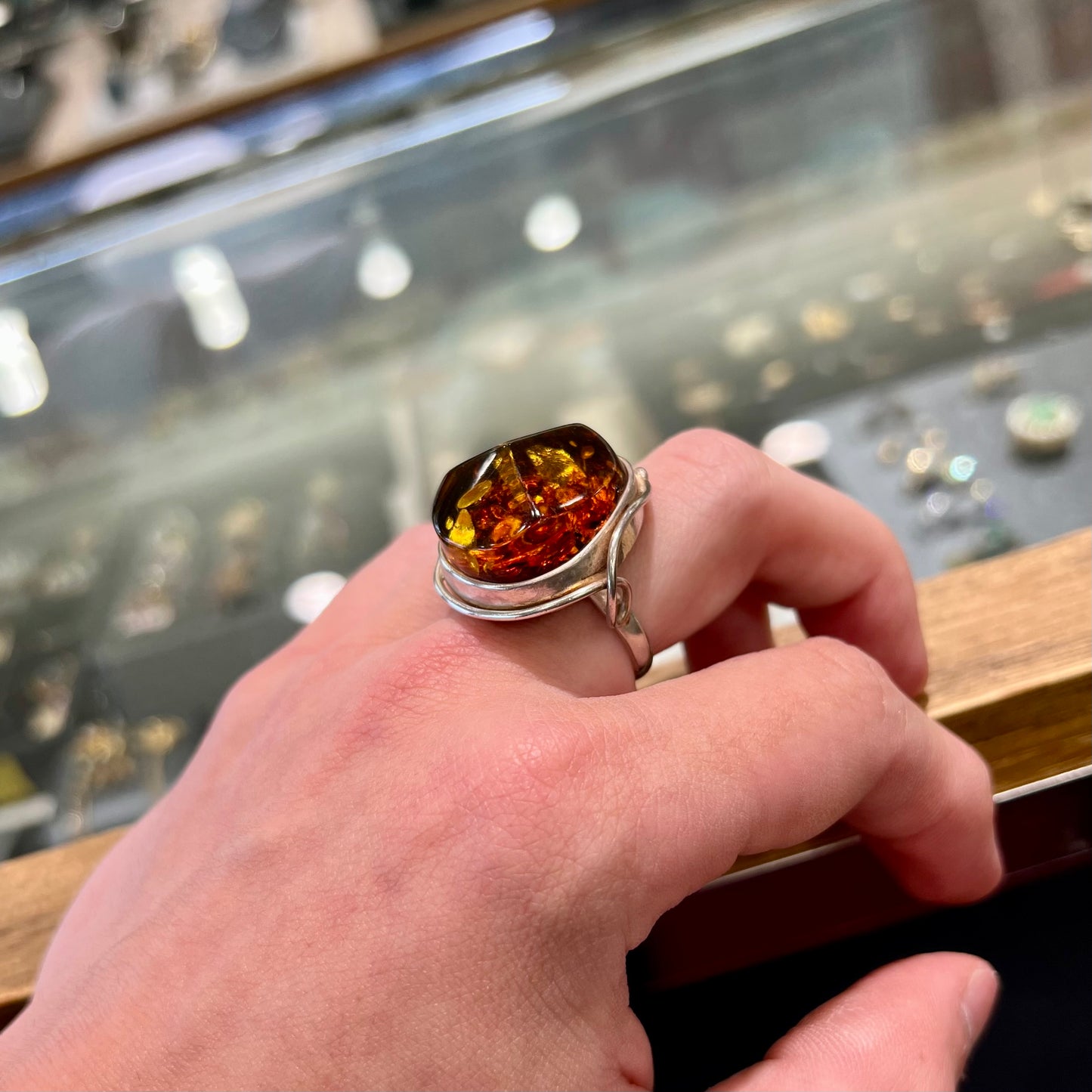 Unisex sterling silver ring set with a large sun-spangled Baltic amber gemstone.