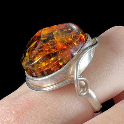 Unisex sterling silver ring set with a large sun-spangled Baltic amber gemstone.