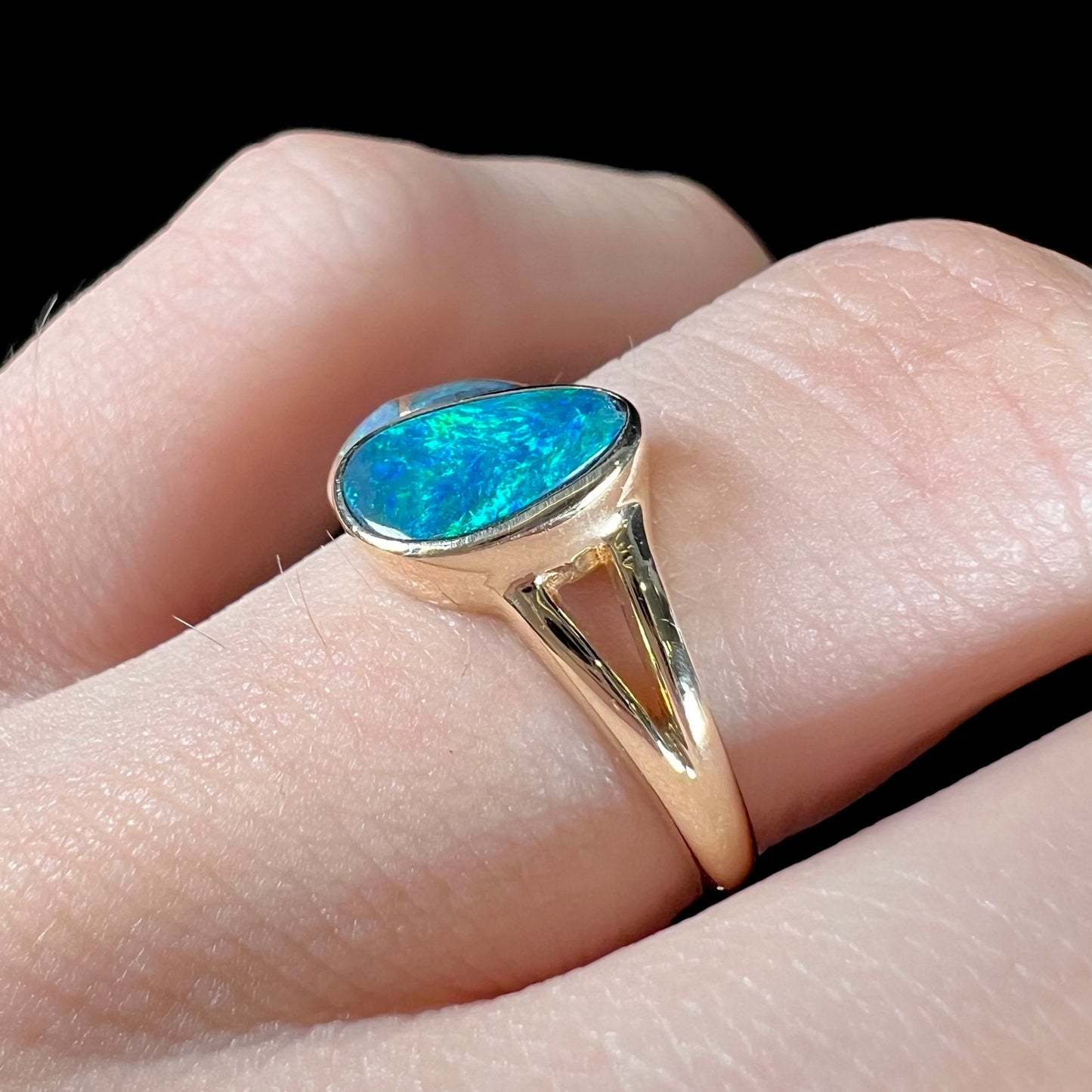 A ladies' black opal inlay ring cast in yellow gold.