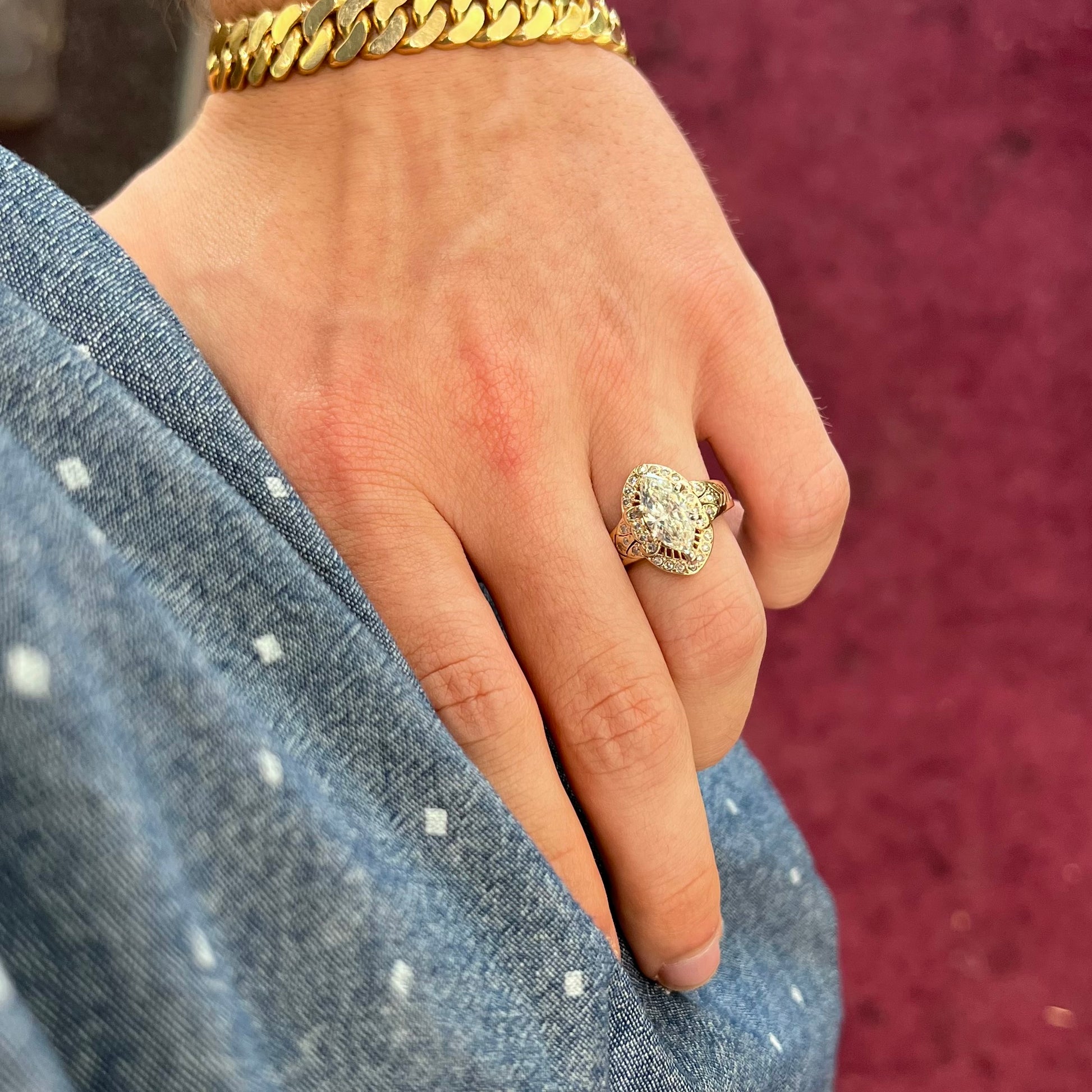 A ladies' yellow gold engagement ring set with a 1.54ct marquise cut natural diamond with round diamond accents.