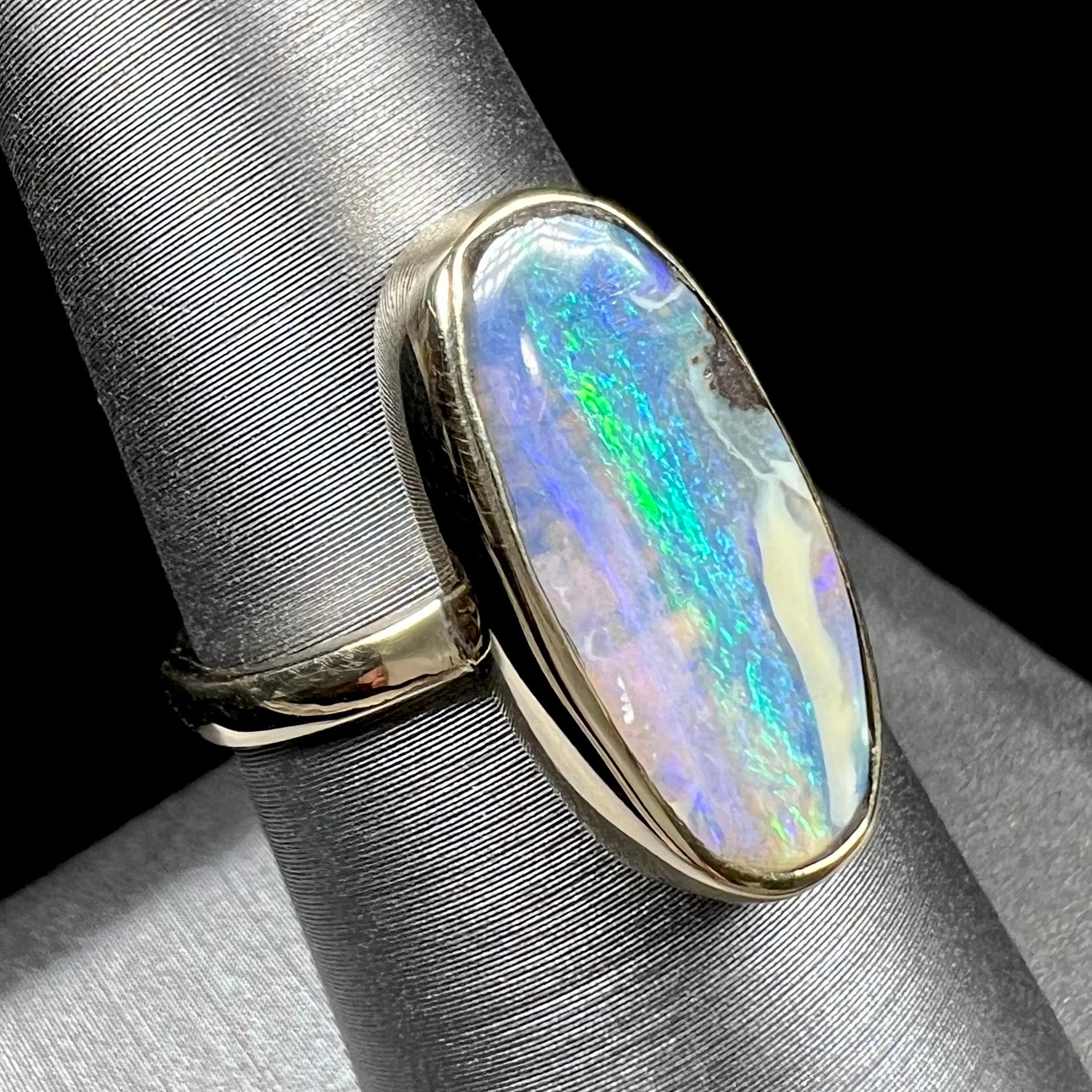 Ladies' yellow gold solitaire ring bezel set with a natural green striped boulder opal from Quilpie, Australia.