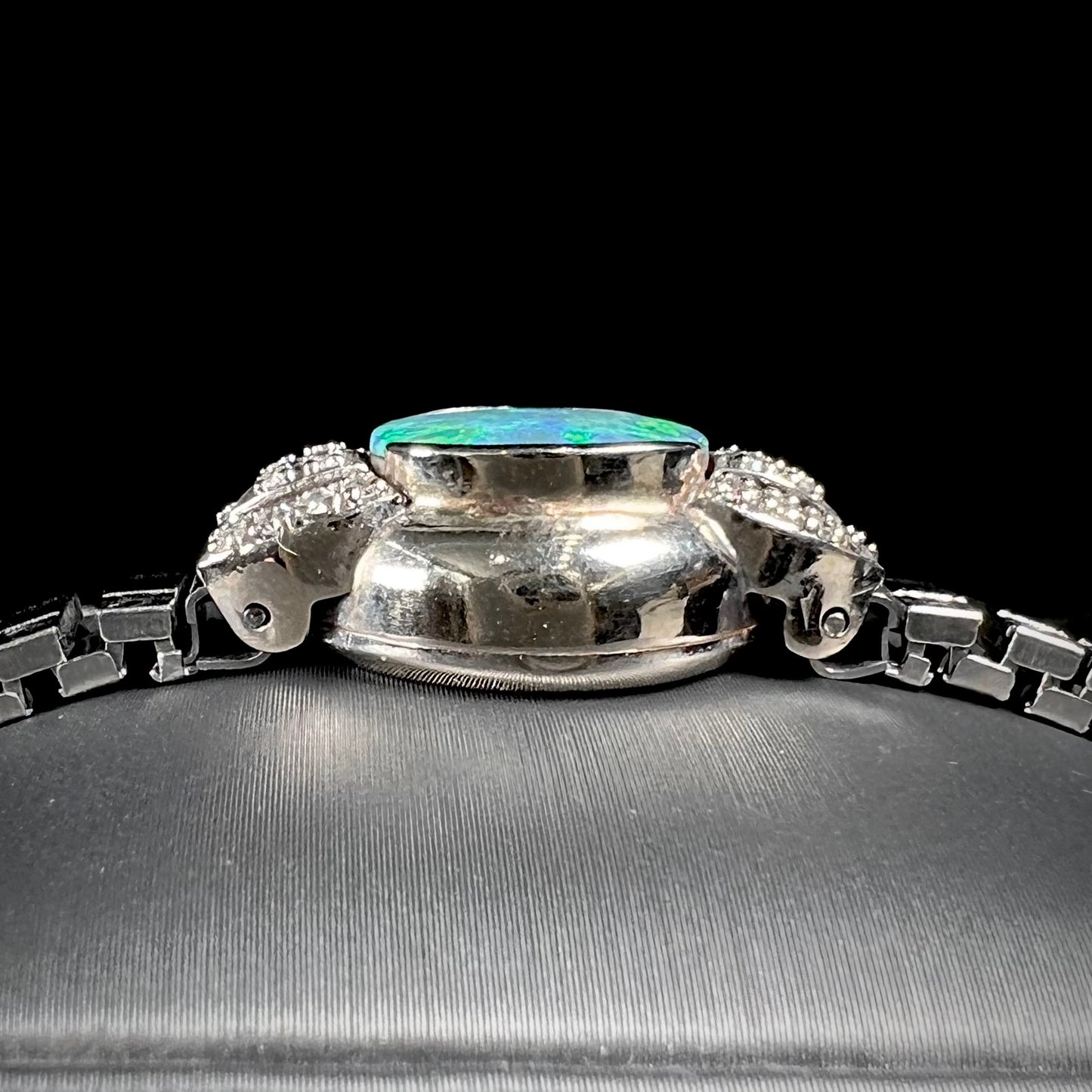 A ladies' art deco style white gold and stainless steel bracelet set with a natural black opal doublet and diamonds.