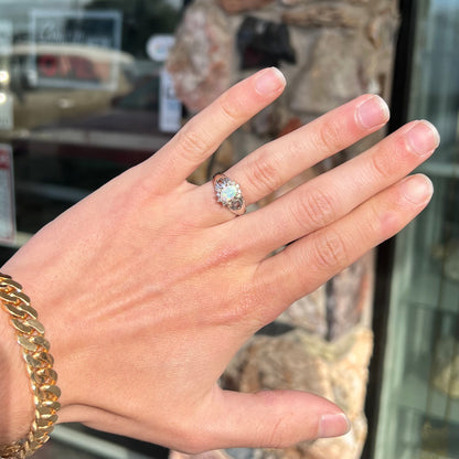 A ladies' white gold ring set with a halo of diamonds and an oval cabochon cut Australian opal.