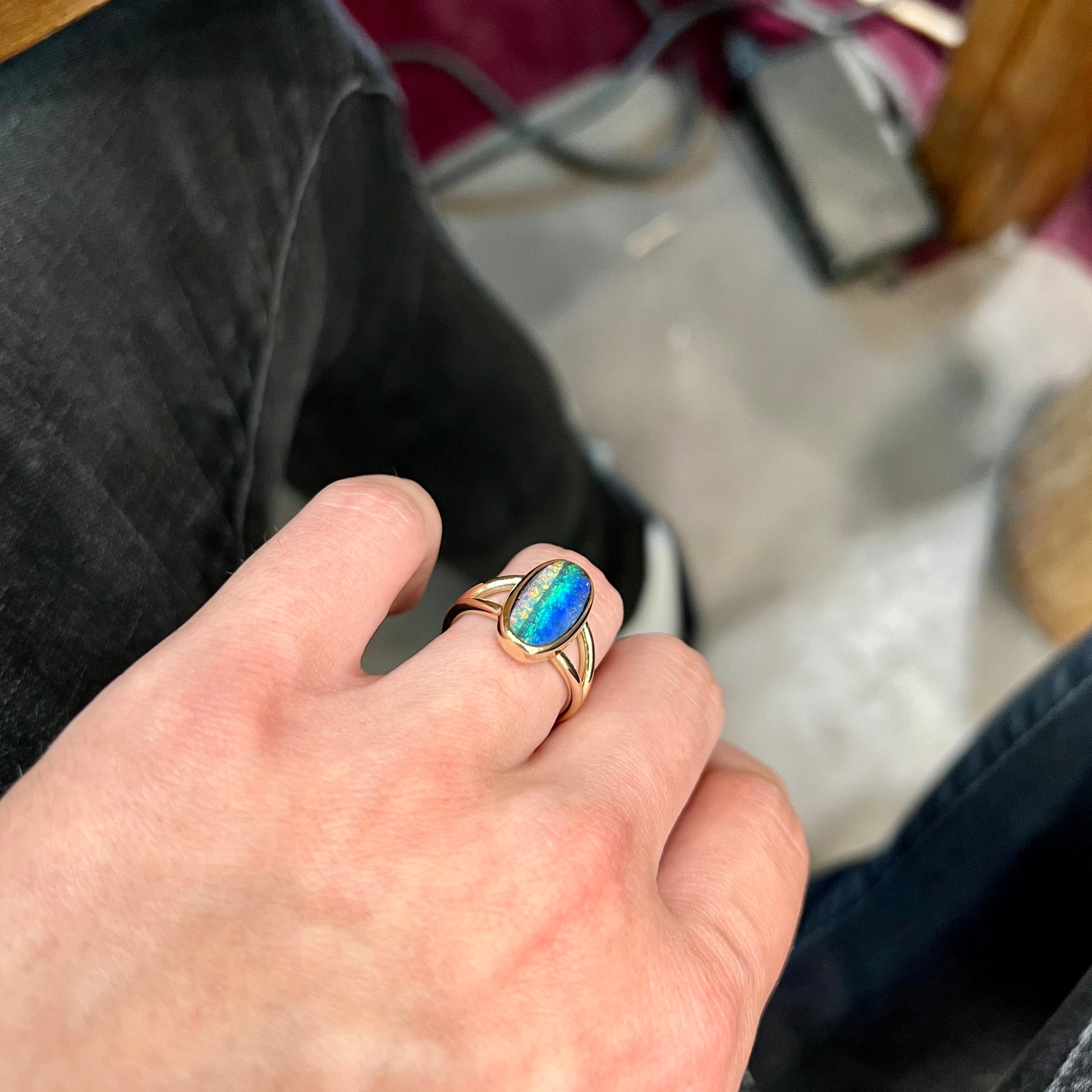 A ladies' yellow gold split shank solitaire ring set with a natural Australian black boulder opal.