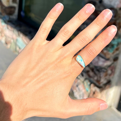 A ladies yellow gold solitaire ring bezel set with a natural opalized seashell from Coober Pedy, Australia.