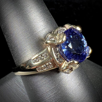 A ladies' yellow gold natural tanzanite and diamond ring.  Diamonds are channel set along the shank and in the prongs.