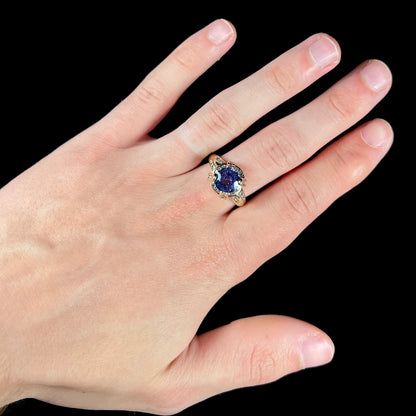 A ladies' yellow gold natural tanzanite and diamond ring.  Diamonds are channel set along the shank and in the prongs.