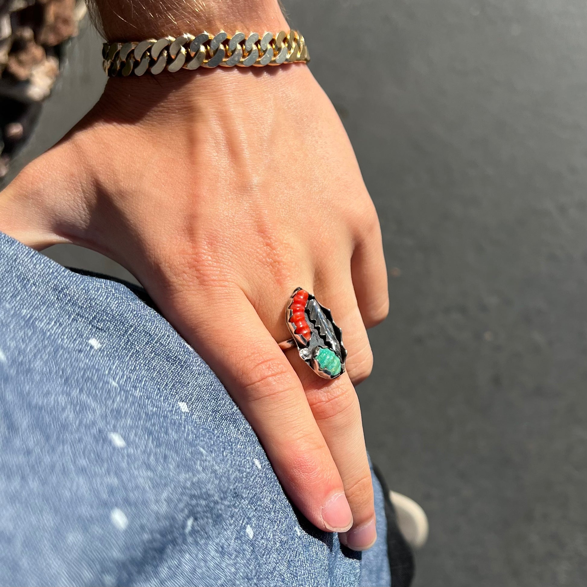 A ladies' vintage Southwest silver ring set with carved Royston turquoise and coral stones.