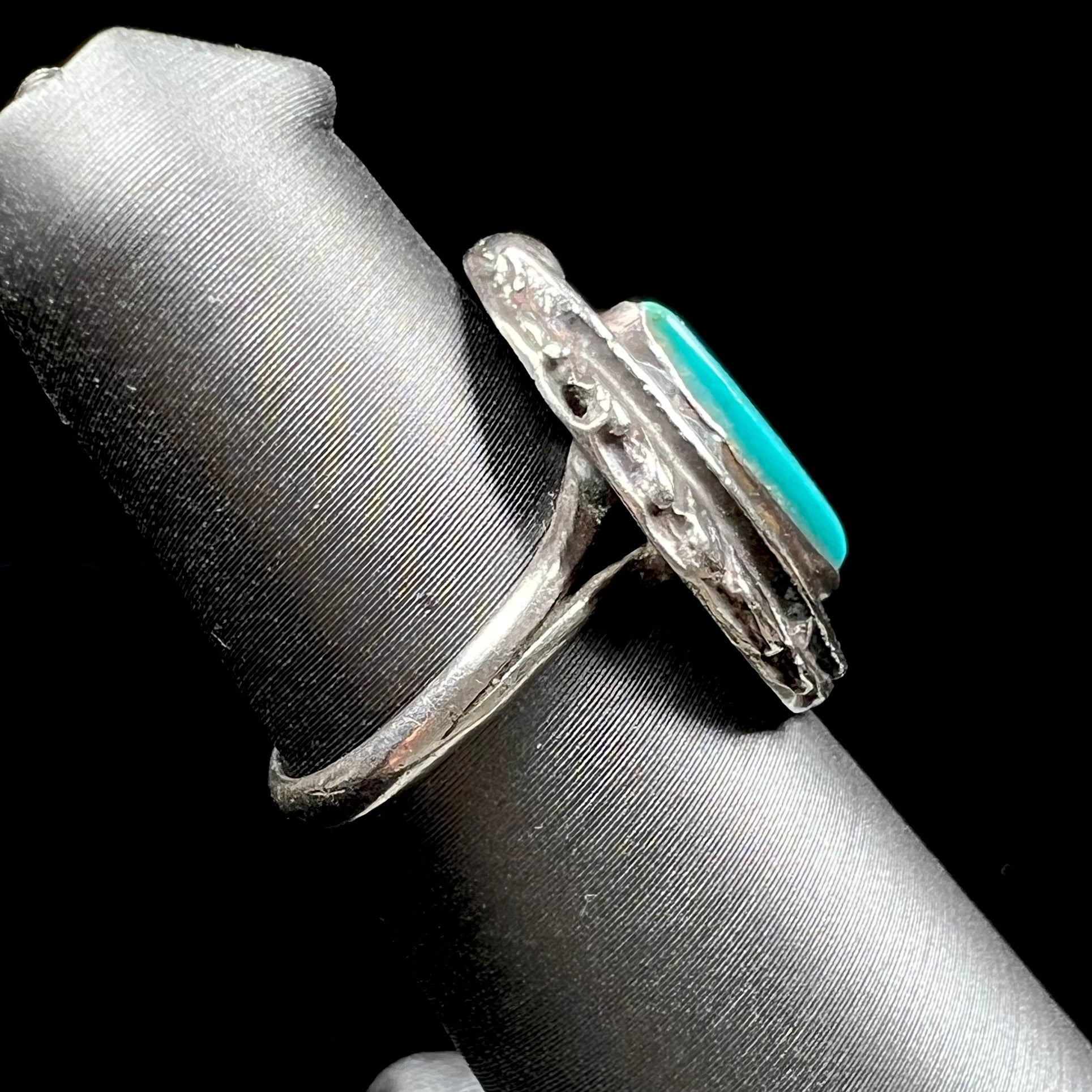 A ladies' sterling silver feather style ring set with a marquise cut turquoise stone.