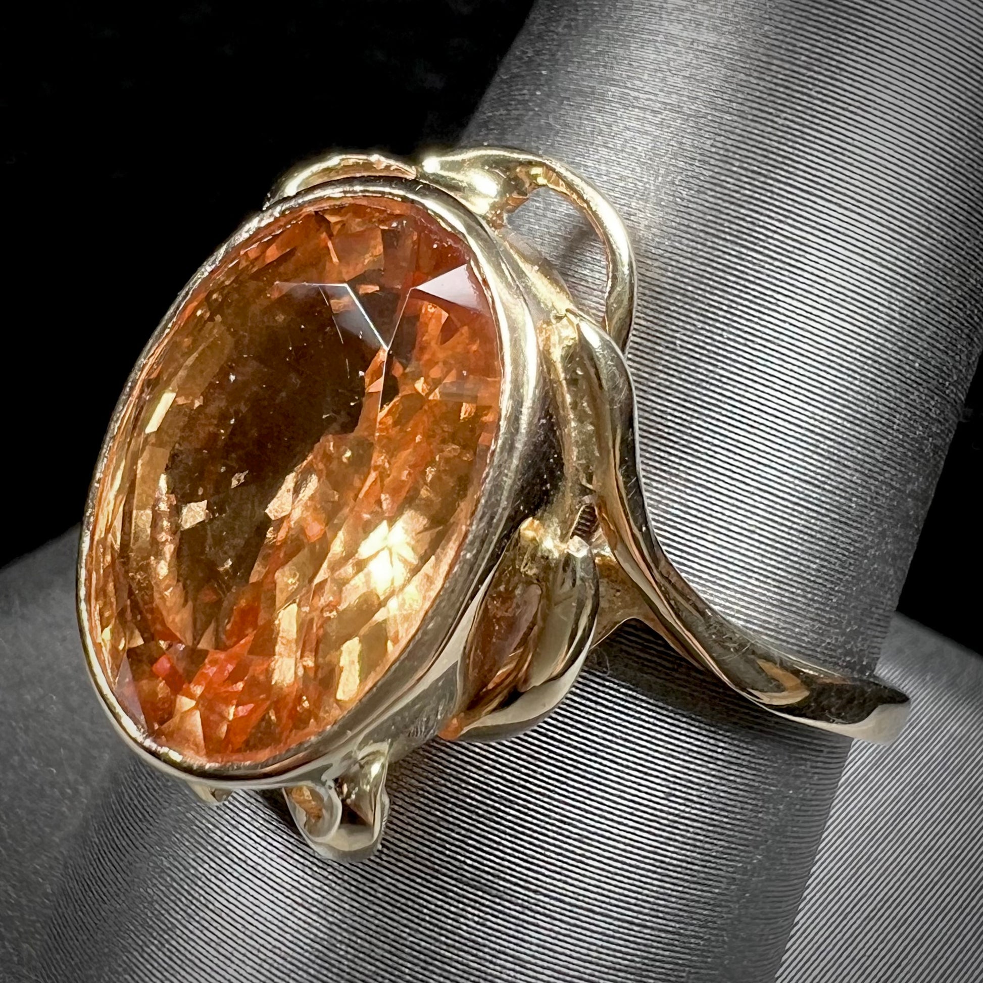 A ladies' yellow gold solitaire ring set with an 8.00 carat oval cut orange hessonite garnet.