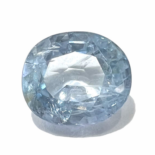 A loose, faceted oval cut light blue natural sapphire gemstone.