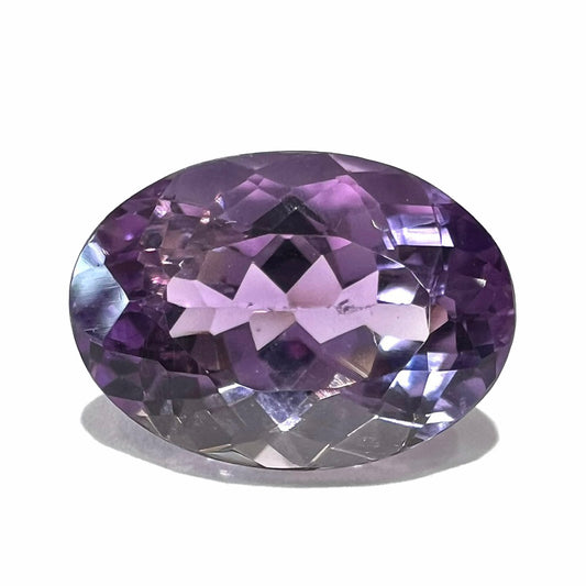 A faceted oval cut amethyst gemstone.  The stone is a light purple color.