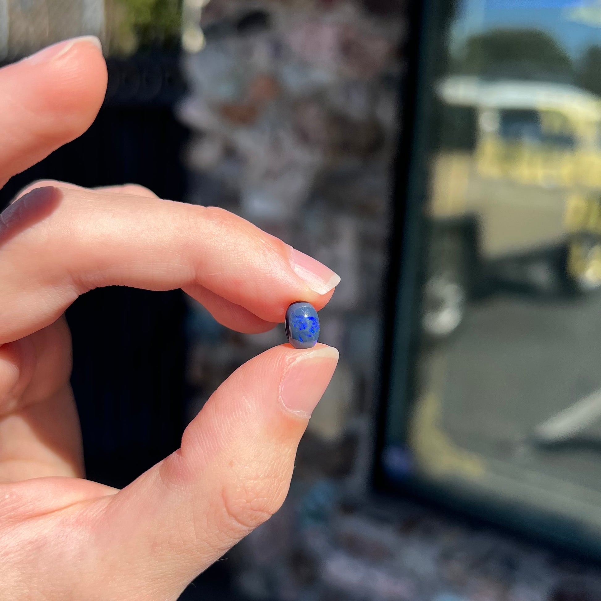 A loose, oval cabochon cut black opal stone from Lightning Ridge, Australia.  The opal has an N2 body tone.