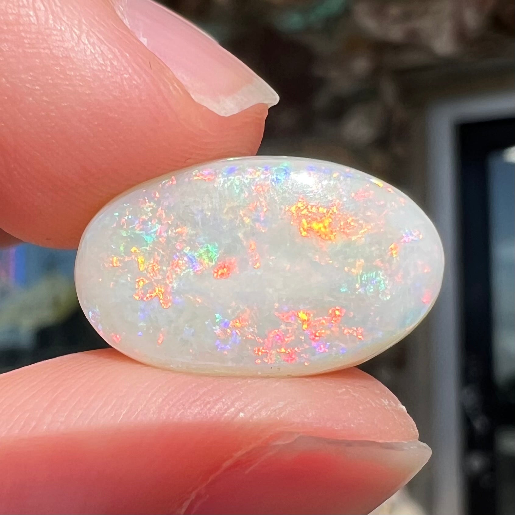 An oval cabochon cut opal from Coober Pedy, Australia.  The opal has predominantly red fire.