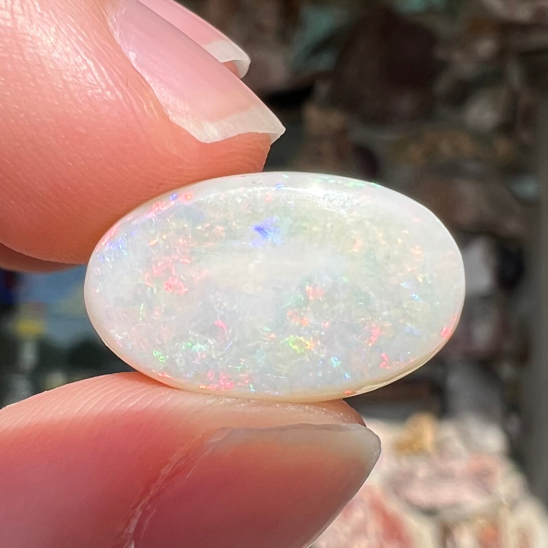 An oval cabochon cut opal from Coober Pedy, Australia.  The opal has predominantly red fire.