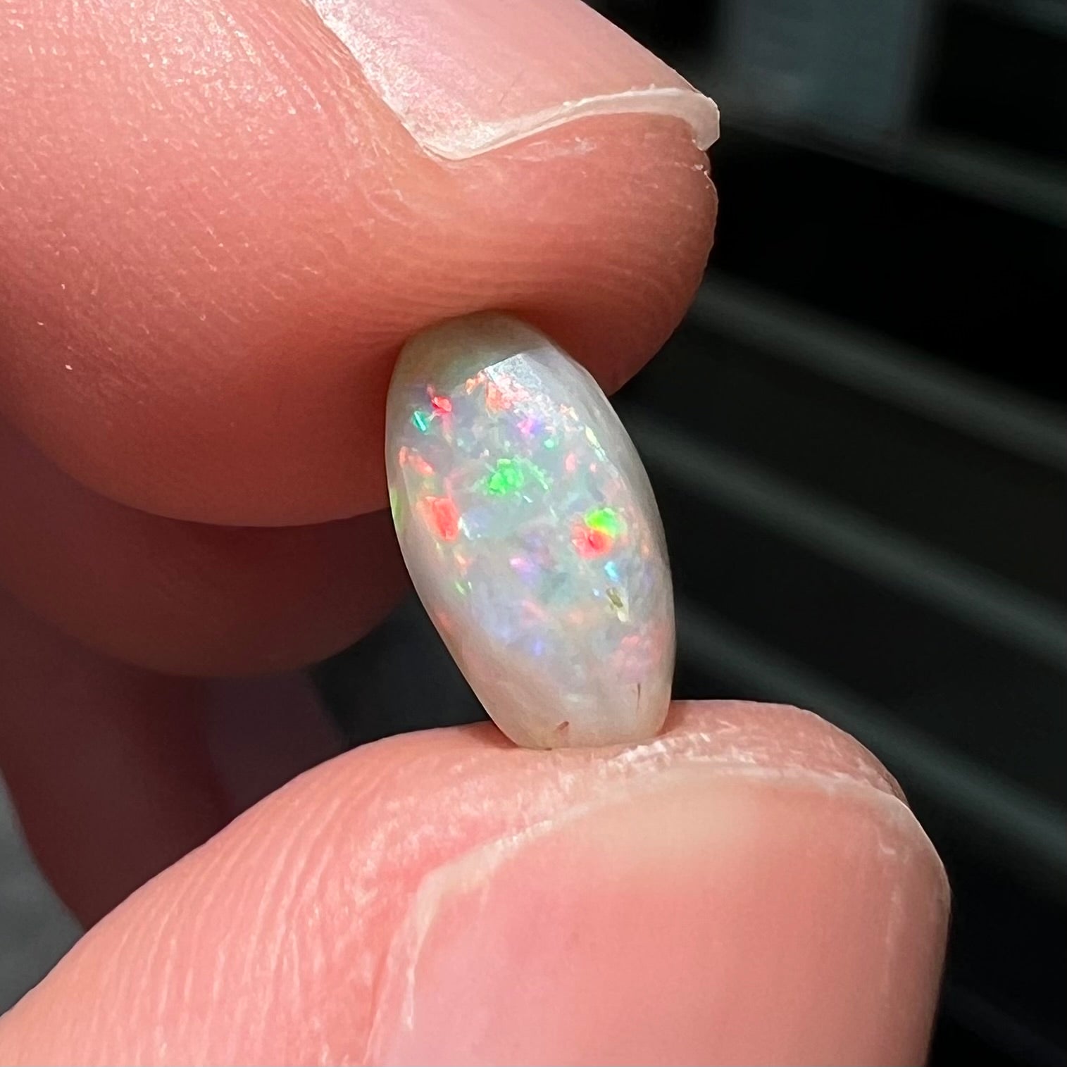 A loose, light opal from Lightning Ridge, Australia.  The opal shines a rainbow of colors.