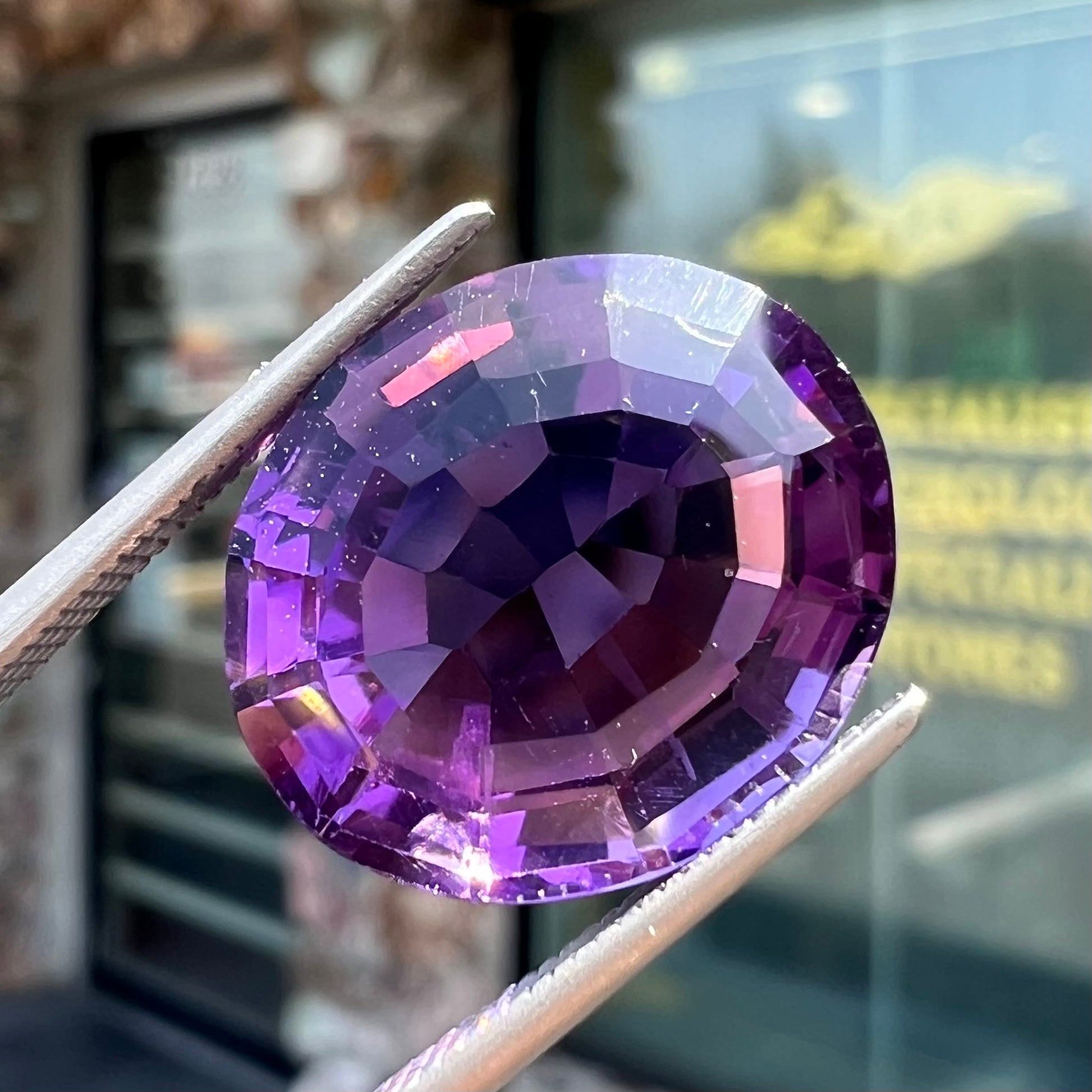 A loose, modified oval cut purple amethyst gemstone.