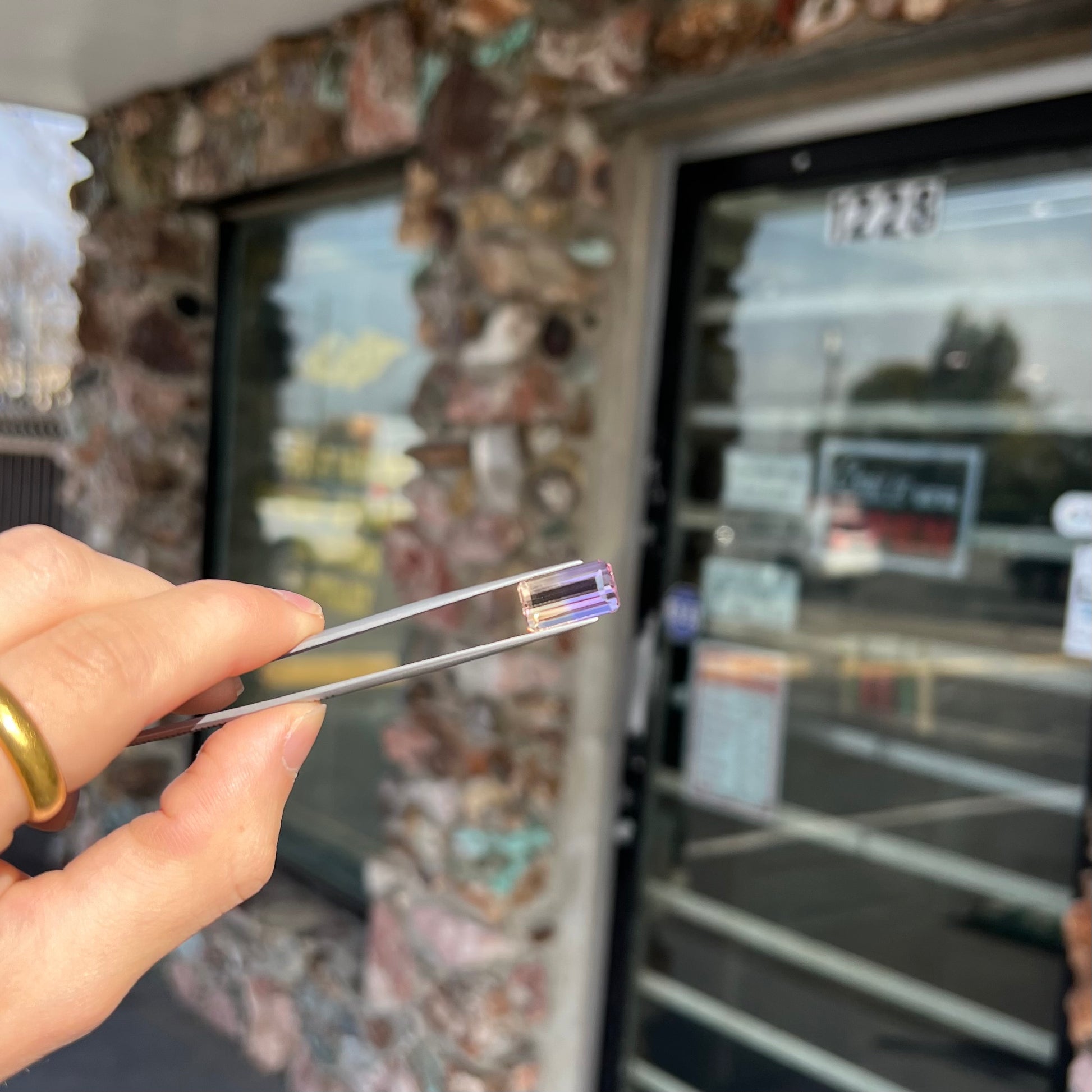 A loose, emerald cut ametrine stone.  The color fades from light purple to light yellow.