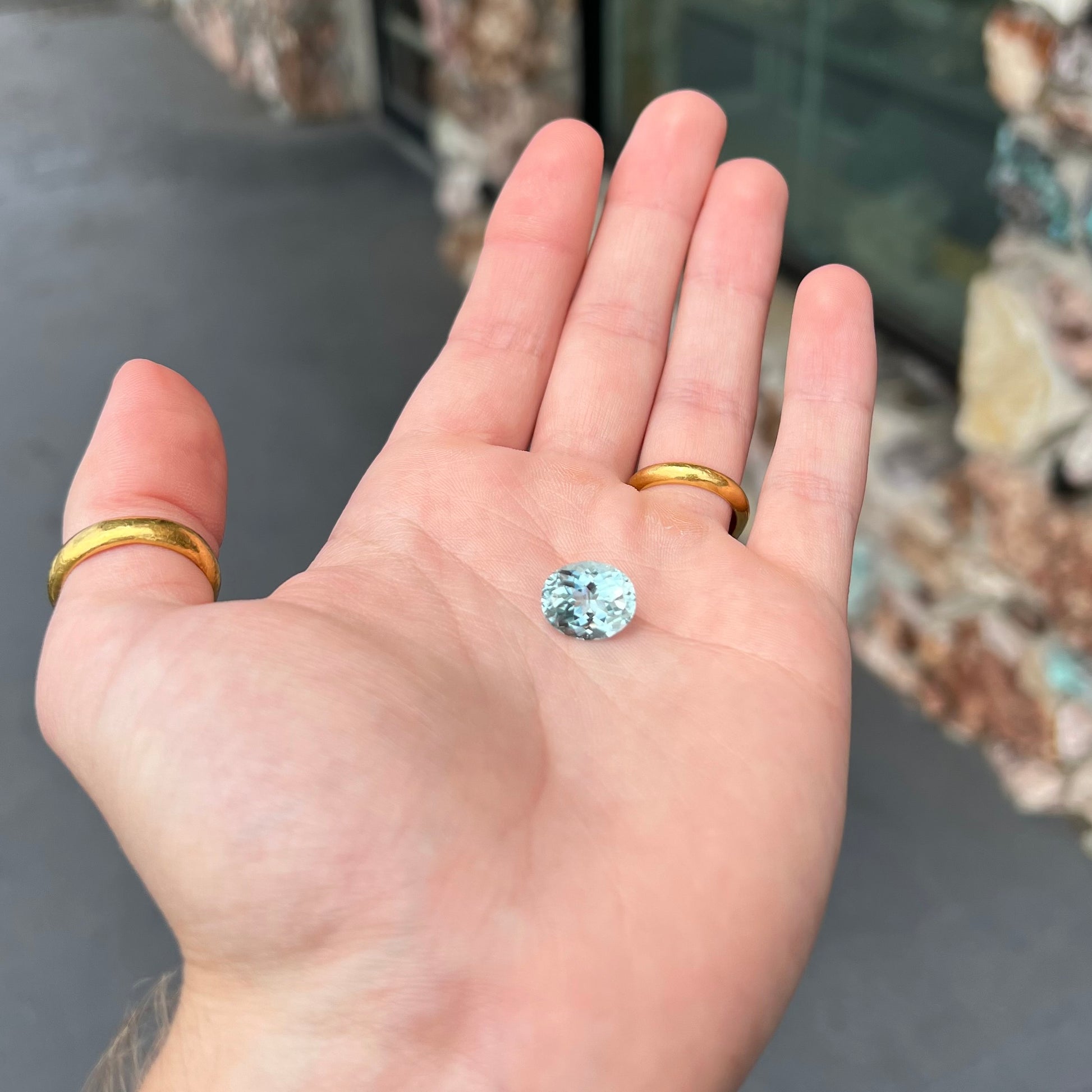 A loose, faceted oval cut aquamarine gemstone from Brazil.  The stone is greenish blue color.