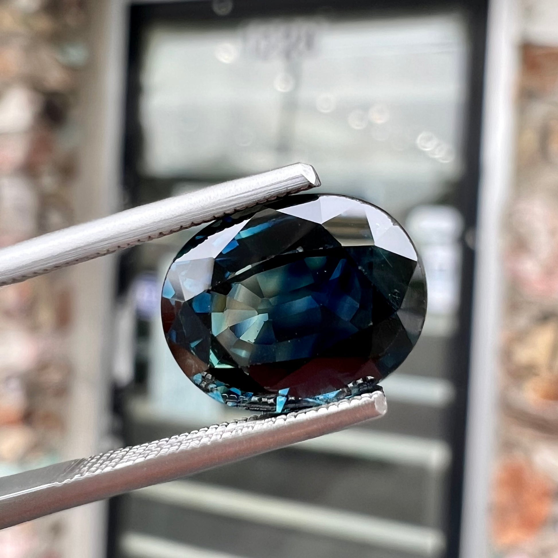 A loose faceted oval cut natural sapphire.  The stone is blue-green color.