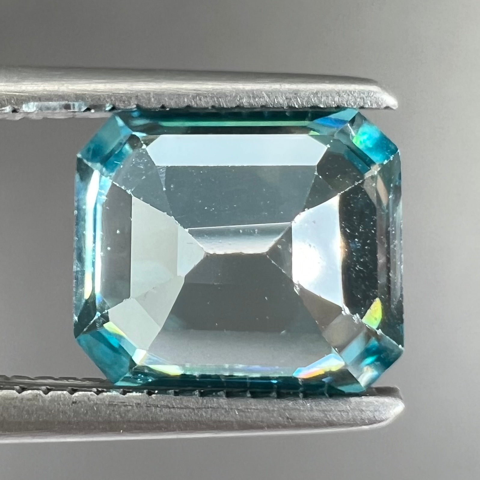 A loose, emerald cut blue zircon gemstone.