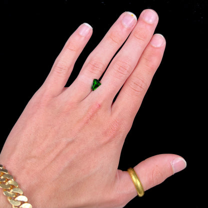A freeform shield cut chrome diopside gemstone.