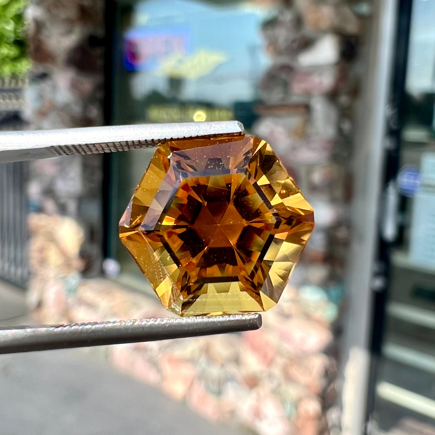A loose, faceted hexagon cut citrine gem.  The stone is golden yellow color.