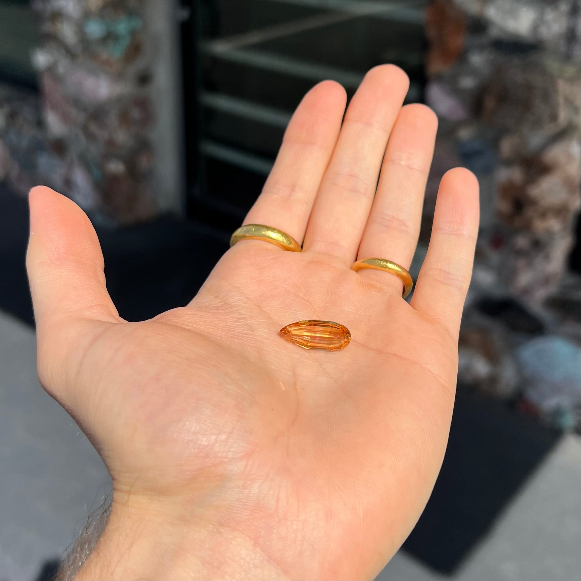 A loose, faceted briolette cut citrine gemstone.