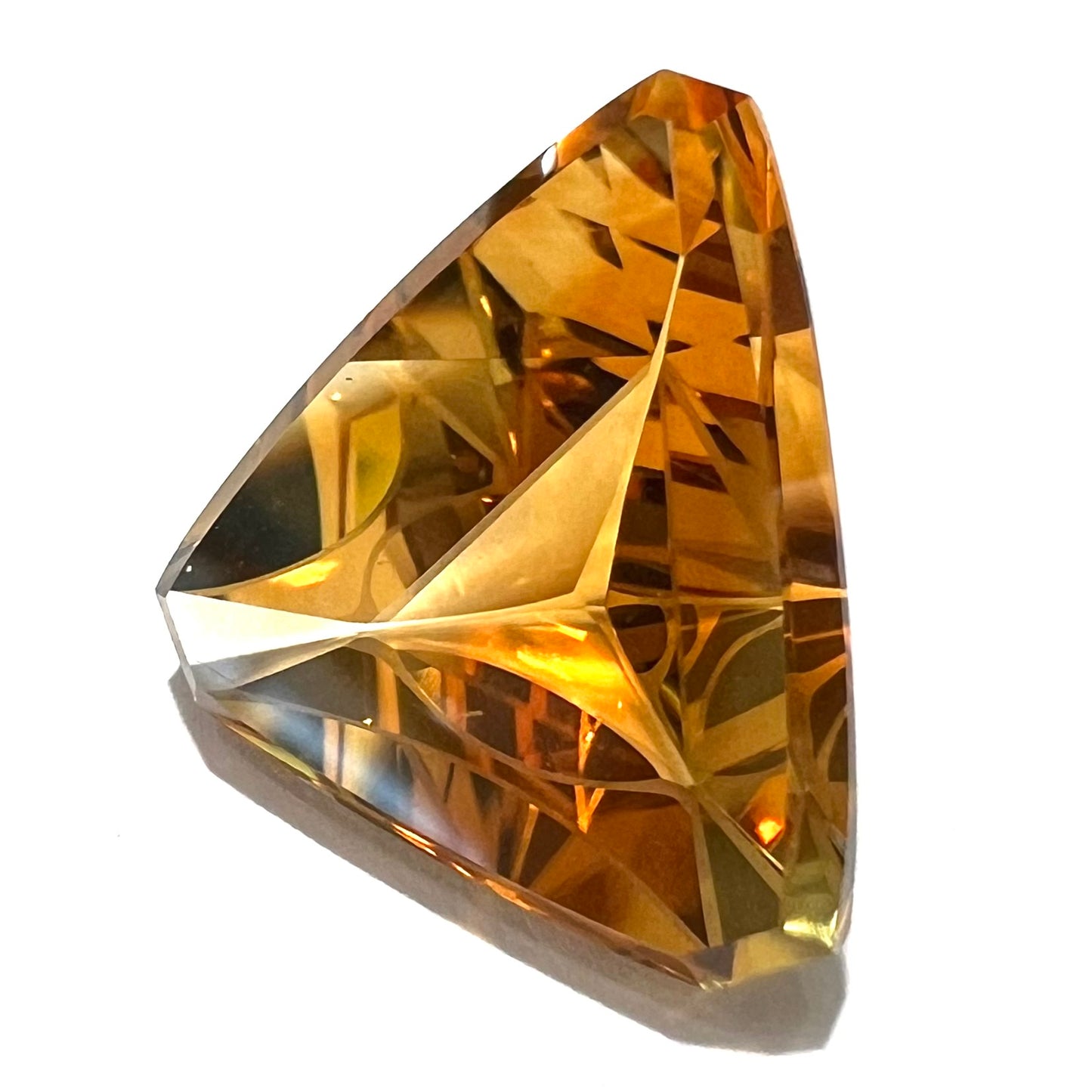 A loose, triangular fantasy cut yellow citrine stone cut by Arthur Lee Anderson.