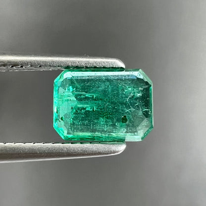 A loose, natural emerald gemstone.  The stone is emerald cut.