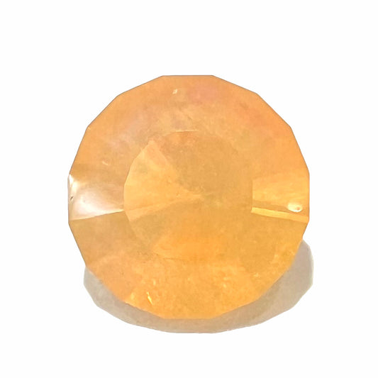 A loose, faceted round cut fire opal from Mexico.  The stone is yellow orange in body color.