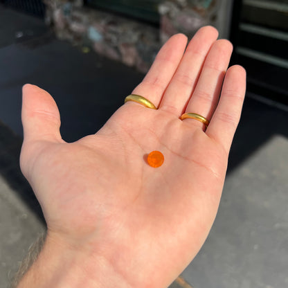 A loose, round faceted cut fire opal from Mexico.  The body color is yellowish orange with red, green, and yellow fire.