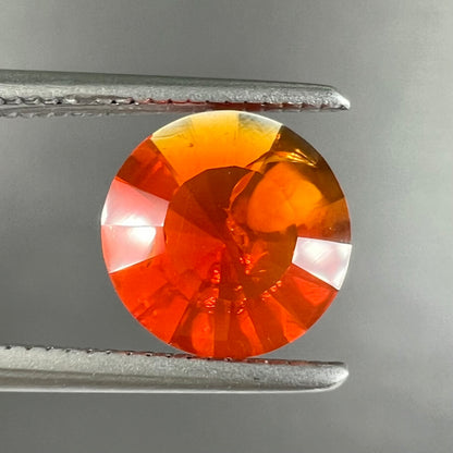 A faceted round cut natural fire opal from Mexico.  The stone is a bright orange color.