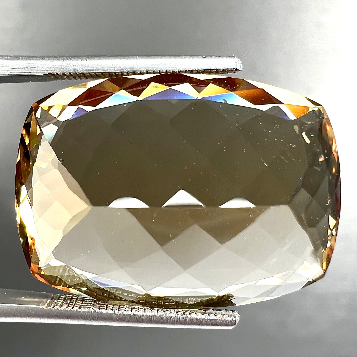 A loose, cushion cut golden beryl stone.