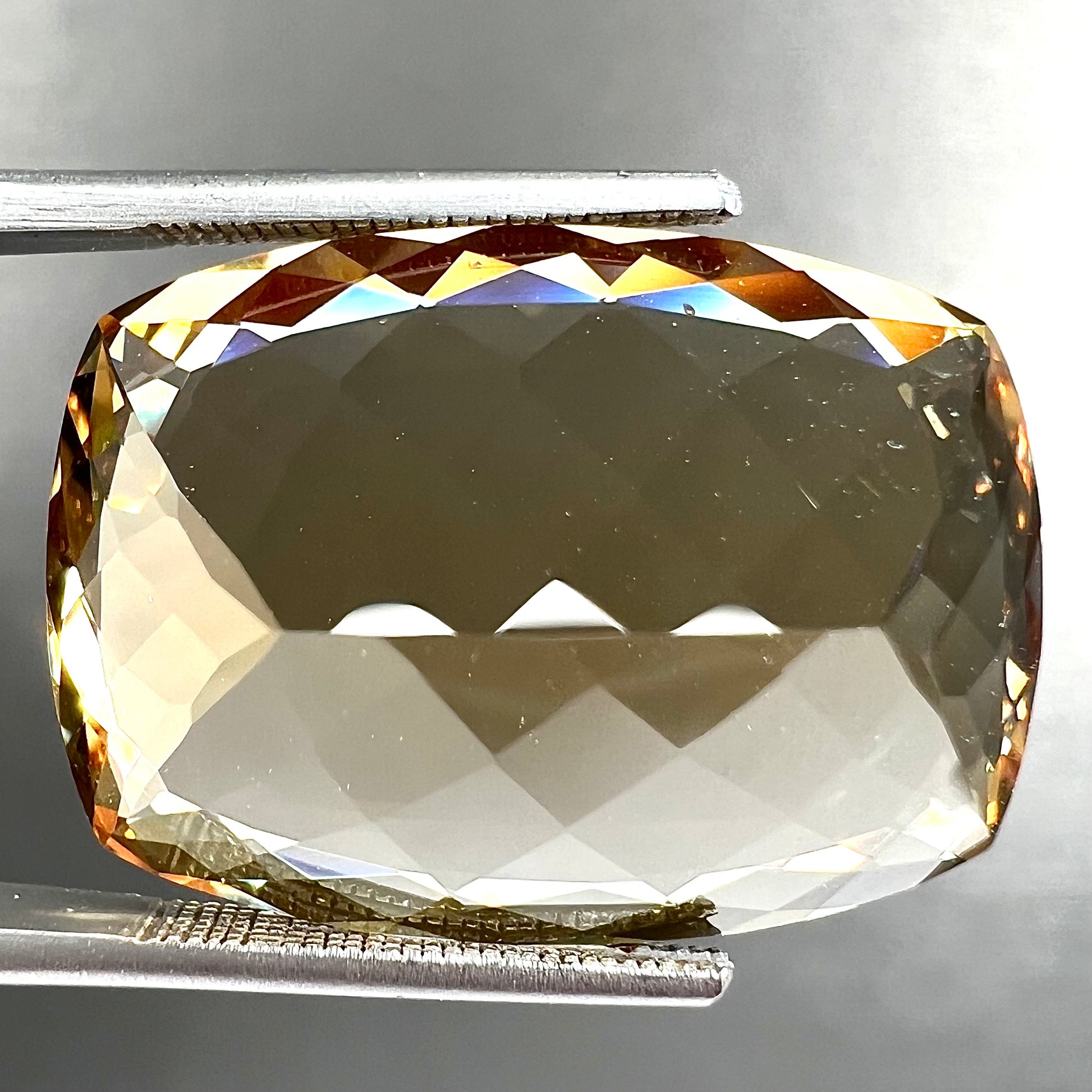 A loose, cushion cut golden beryl stone.