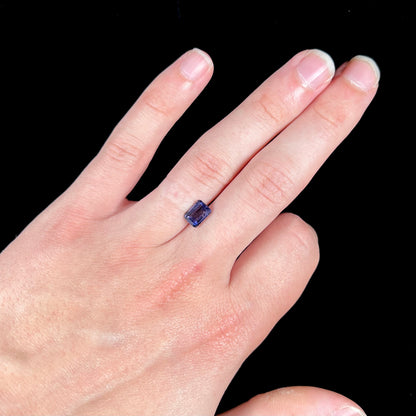 A loose, emerald cut blue iolite gemstone.